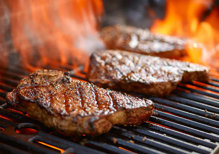 Smoked barbeque seasoning rub on grilled meat over open flames