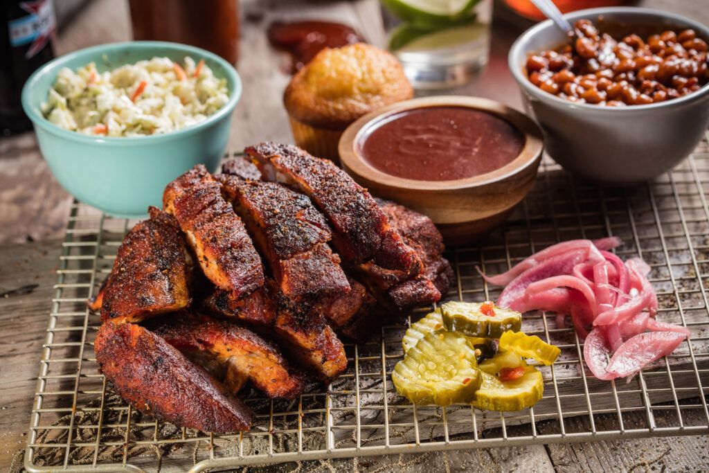 Grilled meat topped with smoked barbeque seasoning rub, with dipping sauce bowls