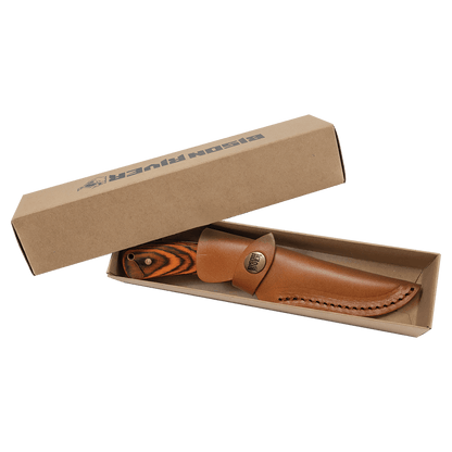 Fixed blade knife with tan leather sheath and striped wood handle, in open cardboard packaging