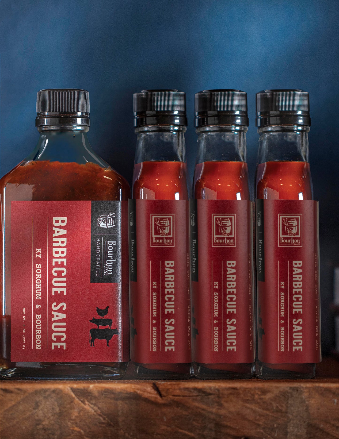 Barbecue sauce bottles set with red bourbon and sorghum labels, dark red sauce
