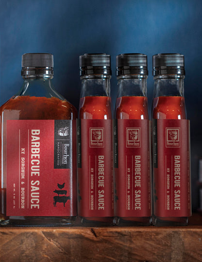 Barbecue sauce bottles set with red bourbon and sorghum labels, dark red sauce