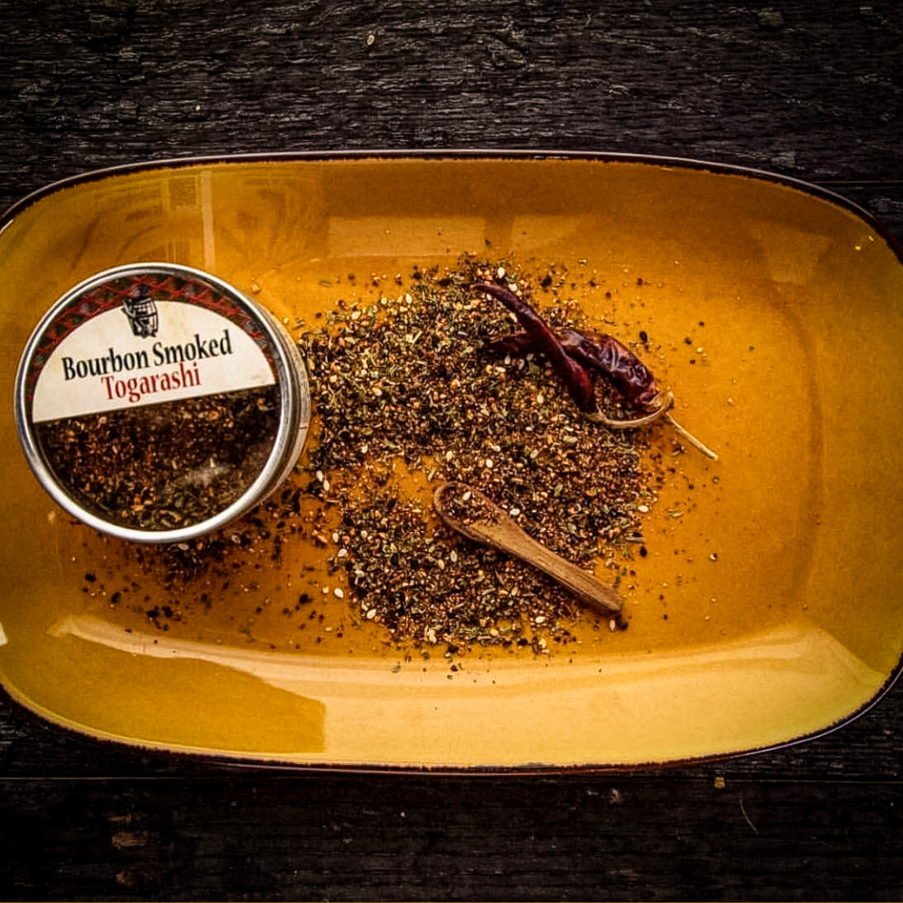 Bourbon smoked togarashi seasoning tin with spice blend and chili on tray