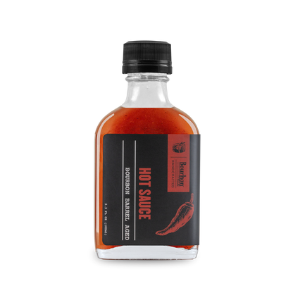 Bourbon barrel-aged hot sauce bottle with red liquid and black label