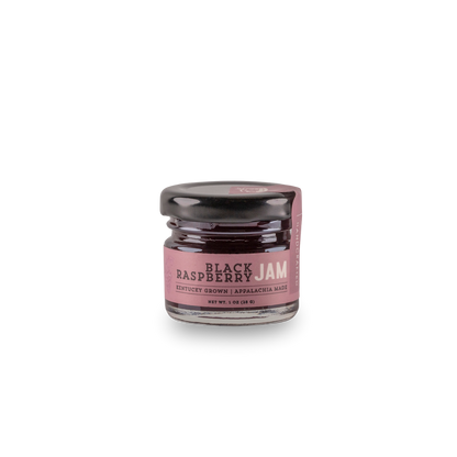 Black raspberry jam jar with pink label and dark filling