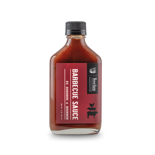 Barbecue sauce bottle with bourbon and sorghum label, dark red sauce
