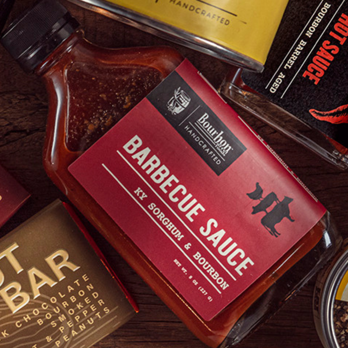 Barbecue sauce bottle with red label reading bourbon and sorghum, dark red sauce