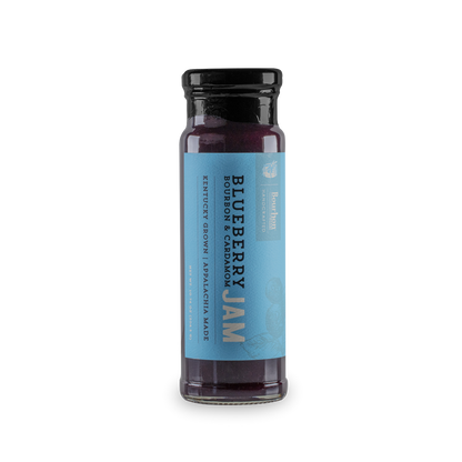 Blueberry cardamom jam jar with black lid, dark purple filling, blue front label.