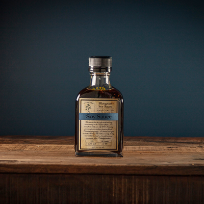 Soy sauce bottle, dark brown liquid, cream label with blue band, metal cap