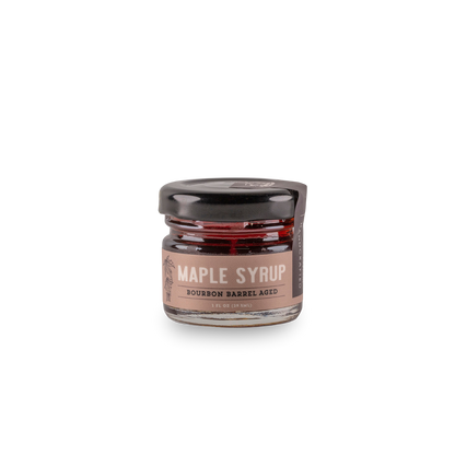 Bourbon barrel-aged maple syrup jar with dark amber syrup and lid