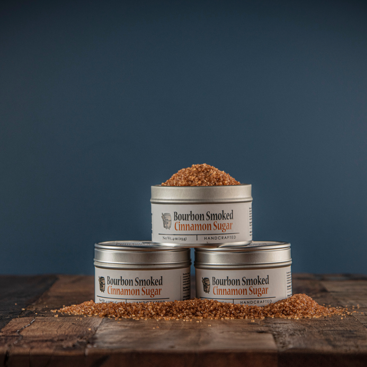 Bourbon smoked cinnamon sugar tins with brown sugar crystals scattered on wood