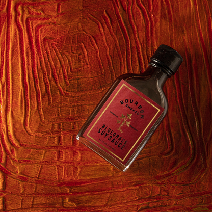 Smoked soy sauce bottle with bluegrass label and black cap, angled view