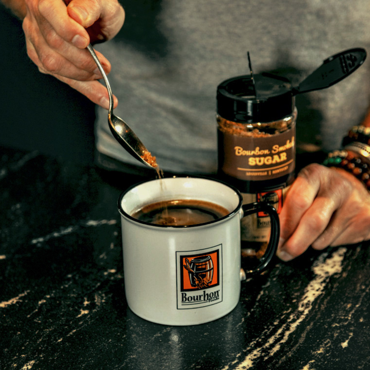 Smoked sugar jar and mug with brown sugar in spoon, countertop with granules