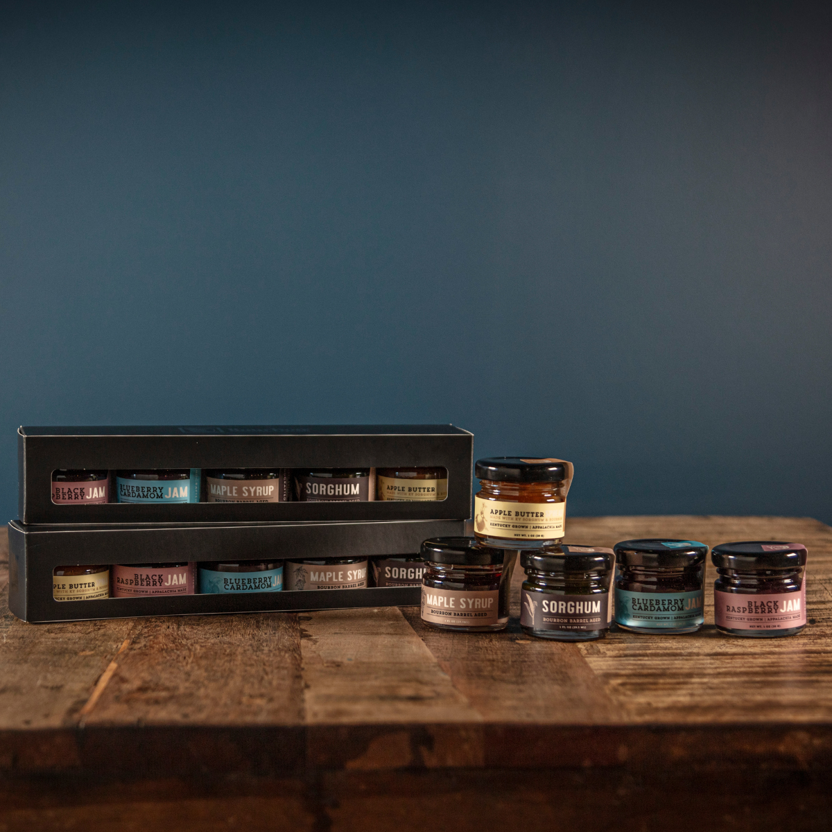 Bourbon barrel jams gift set with five mini jam jars beside gift box on wood