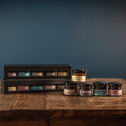 Bourbon barrel jams gift set with five mini jam jars beside gift box on wood