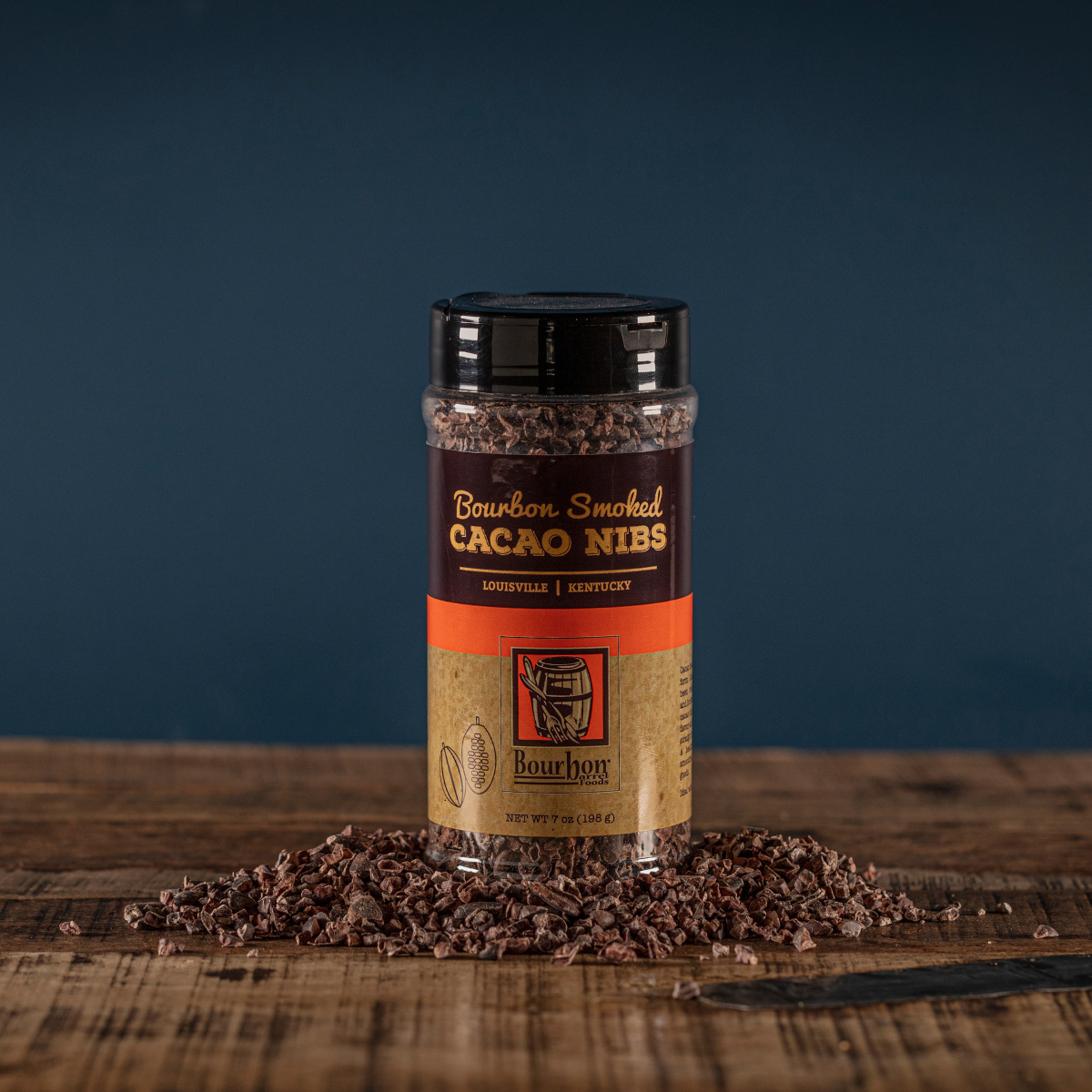 Cacao nibs jar with dark cap and orange label, topped with cacao nibs