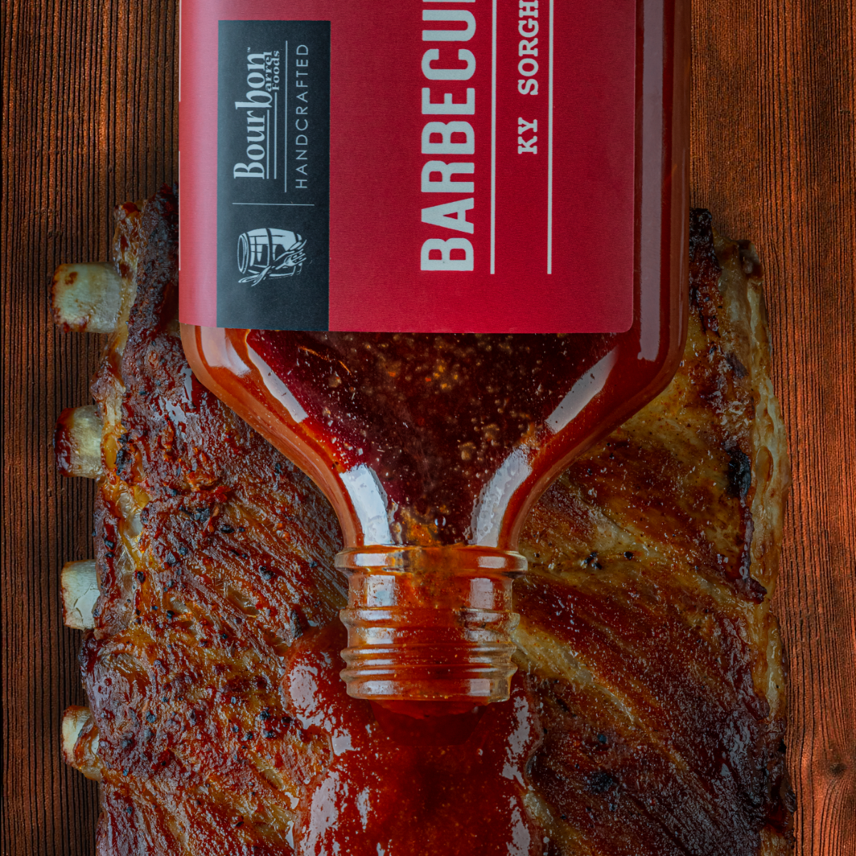 Barbecue sauce bottle with red label and metal cap, dark red sauce