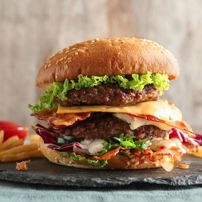 Cheeseburger with lettuce, tomato, and melted cheese on a black plate