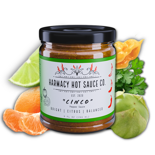 Hot sauce jar with black lid and green label, chili pepper graphics