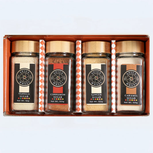 Four spice-labeled sugar jars: vanilla, cinnamon, ginger, caramel in gift box