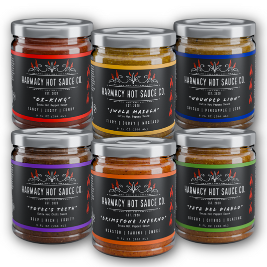 Hot sauce sampler with six glass jars and metal lids; red, blue, purple, orange labels