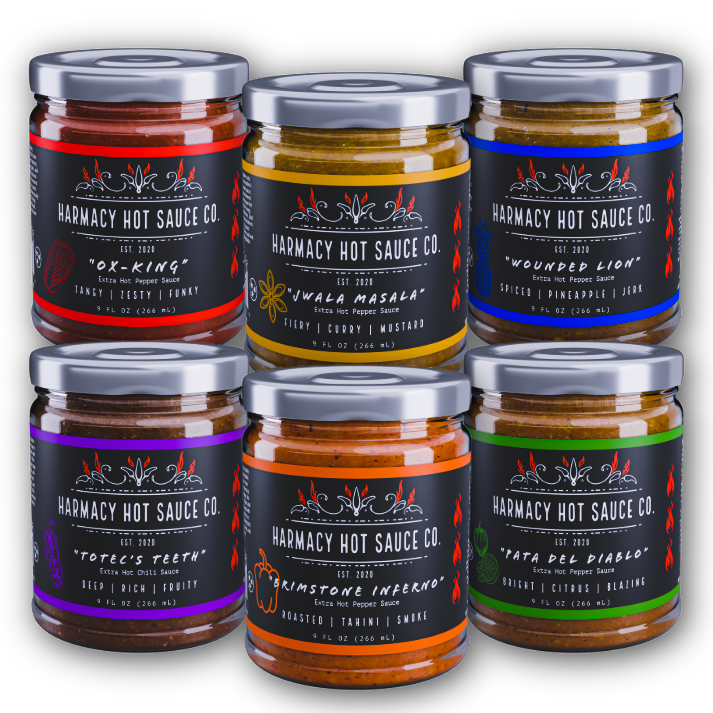 Assorted hot sauce jars with metal lids, six colorful labels
