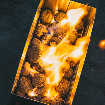 Orange fire pit burner with flames visible inside the steel mesh