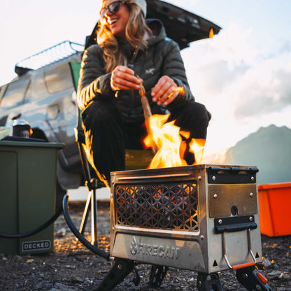 Orange portable fire pit showing steel mesh firebox with flames and control panel