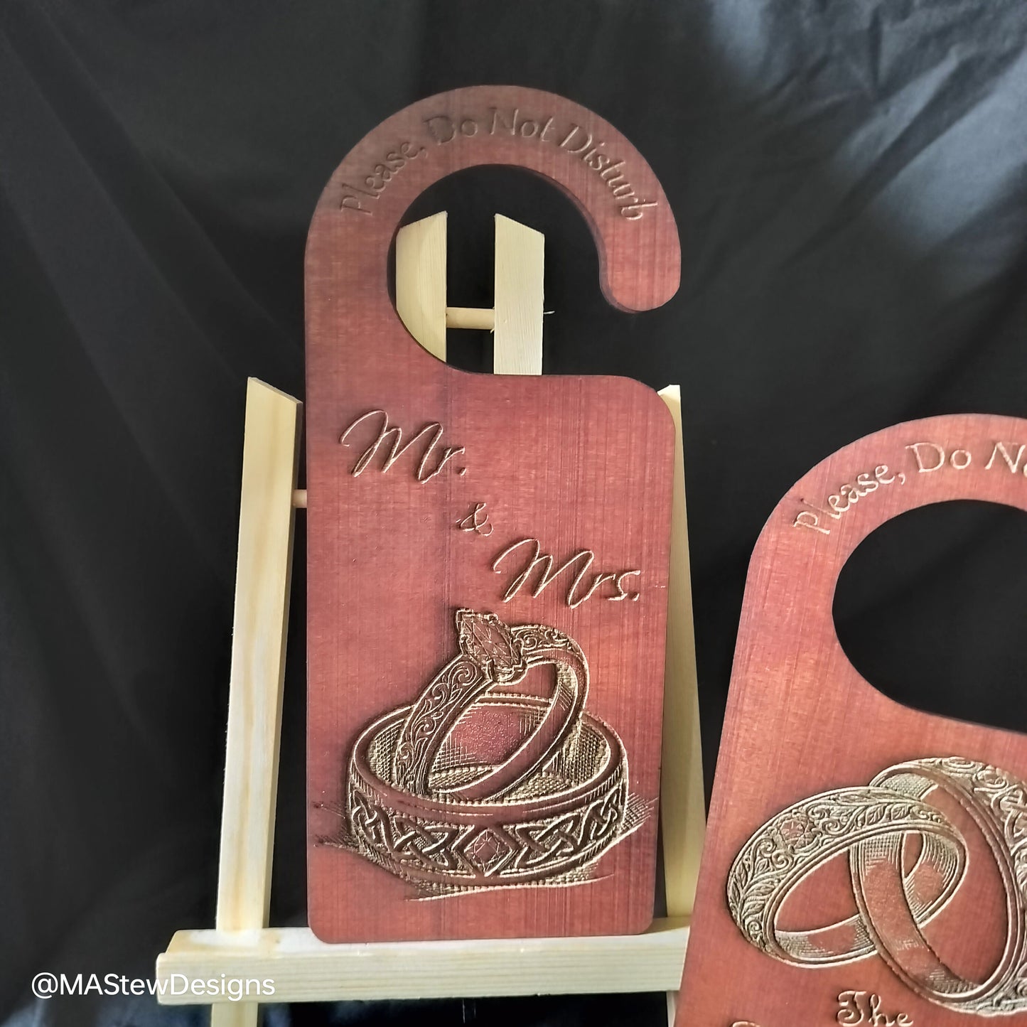 Wooden door hanger with 'Mr. & Mrs.' and wedding rings design on a black background.