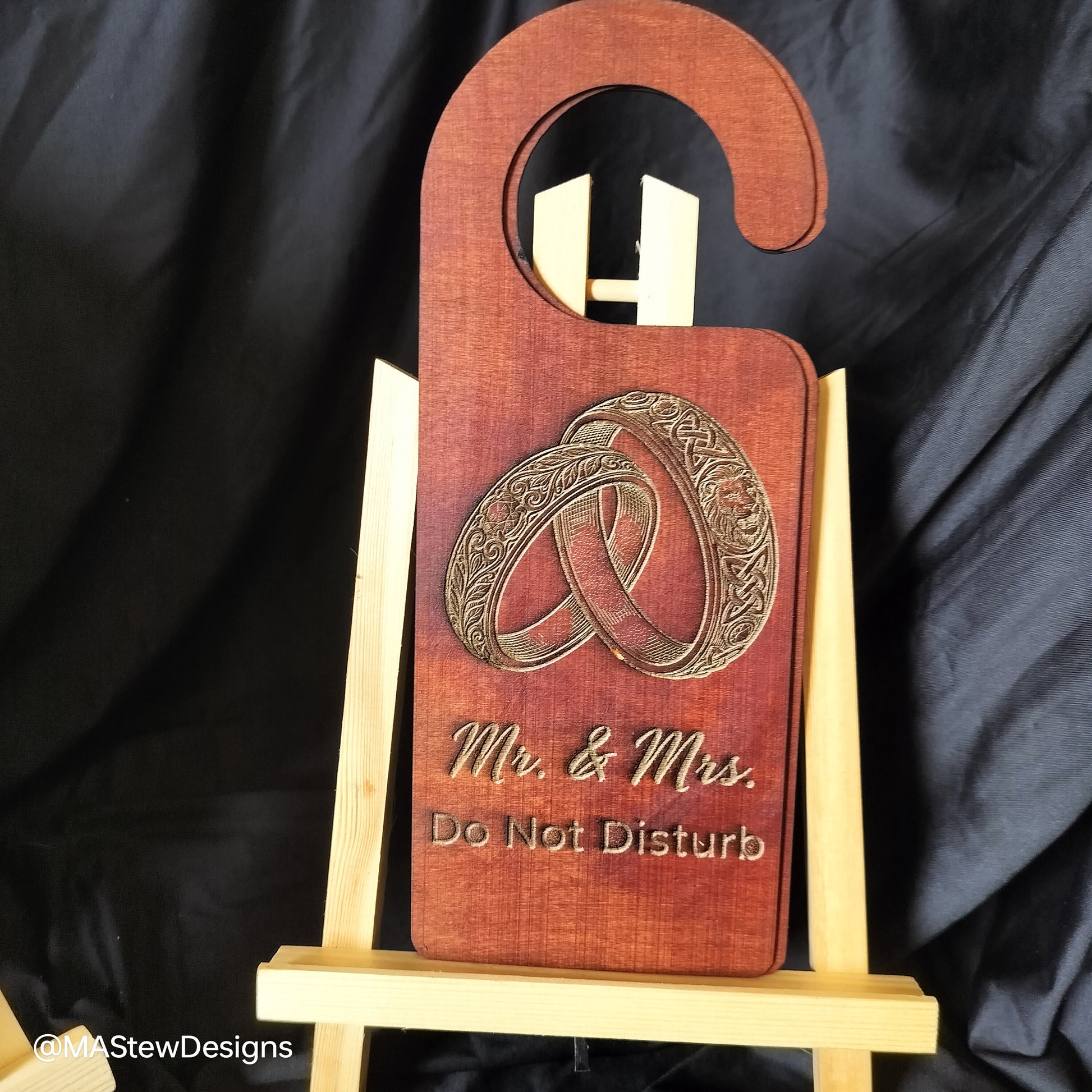 Wooden door hanger with 'Mr. & Mrs. Do Not Disturb' engraving on a black background