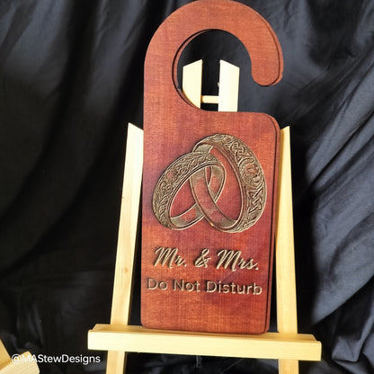 Wooden door hanger with 'Mr. & Mrs. Do Not Disturb' engraving on a black background