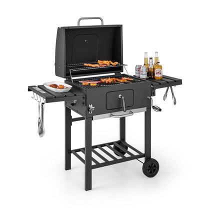 Black charcoal grill with open lid, side hooks, front door panel, and extra prep shelves