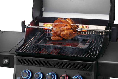 Black gas grill with rotisserie chicken on cooking grates, blue control knobs