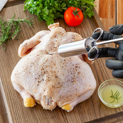 Meat injector tool injecting chicken on wooden board with marinade cup