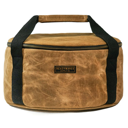 Insulated Dutch oven cover with tan fabric, black handles, and top zip closure