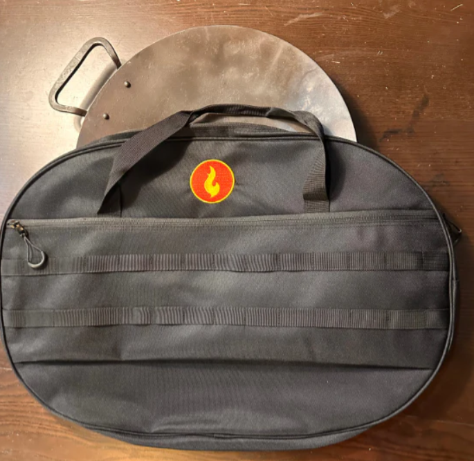 Round black protective bag with flame emblem and carry strap for grill accessories