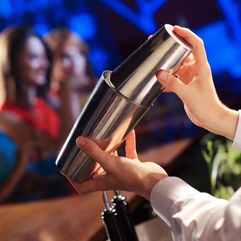 Stainless cocktail shaker held in hands for mixing drinks