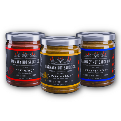 Three hot sauce jars with red, yellow, and blue labels, capped lids