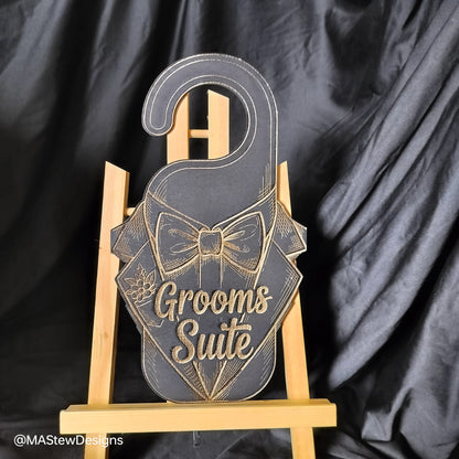 Decorative sign with 'Grooms Suite' text on a stand against a black background