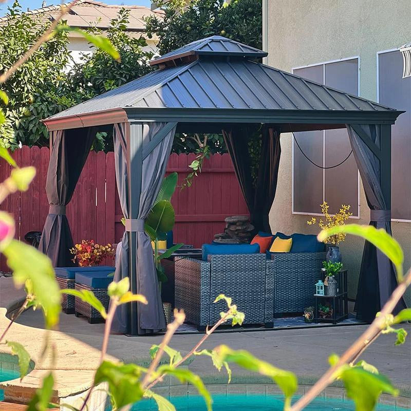 Hardtop gazebo with dark gray frame and roof, open curtains, patio seating near pool