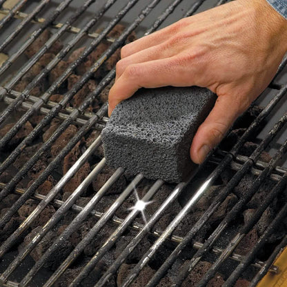 Pumice grill cleaning block rubbed on dark metal BBQ grates for scrubbing