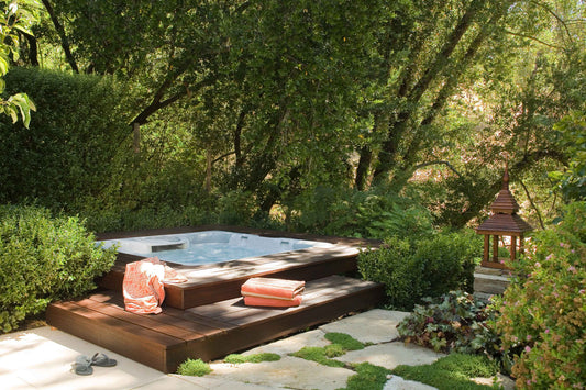 Outdoor rectangular hot tub with wood paneling and stone patio surround