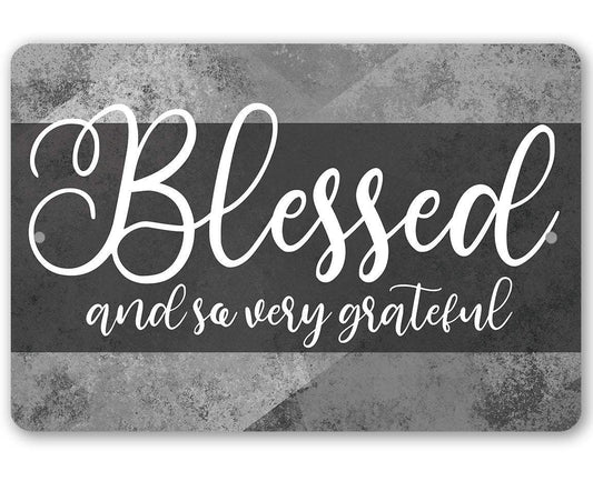 Aluminum wall sign reading “Blessed and so very grateful” in white script on dark gray