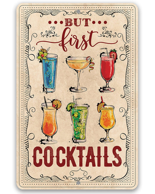 Decorative metal sign with 'But first cocktails' lettering and illustrated drinks