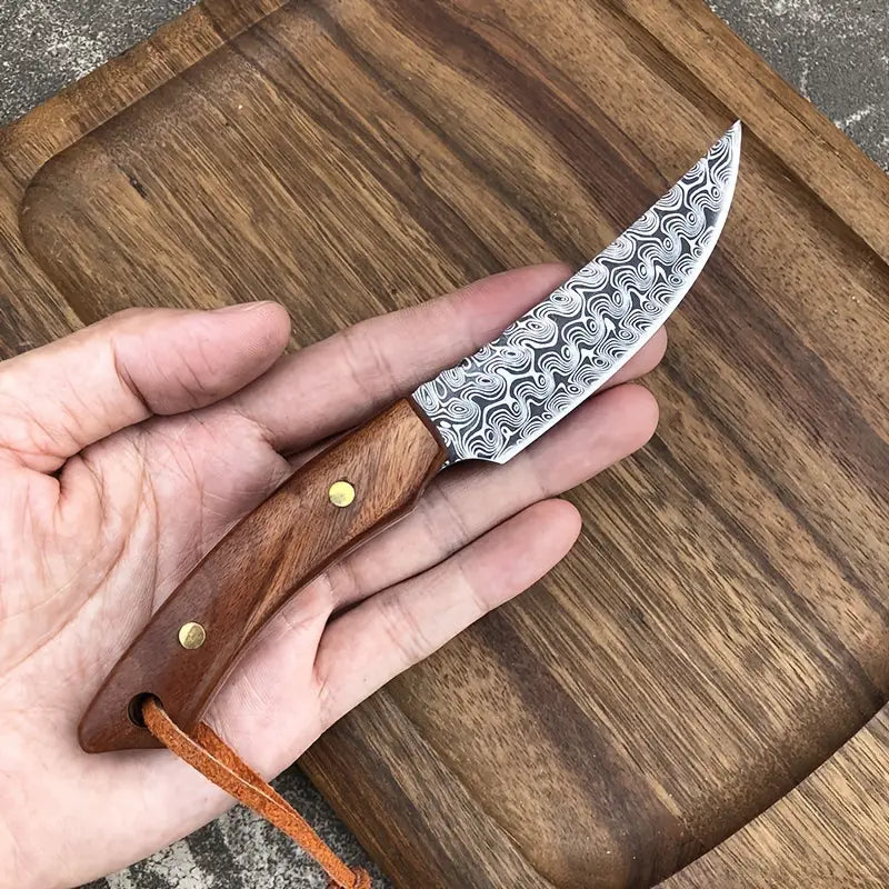 Meat scimitar knife held in hand; damascus-pattern blade and wooden handle with brass rivets