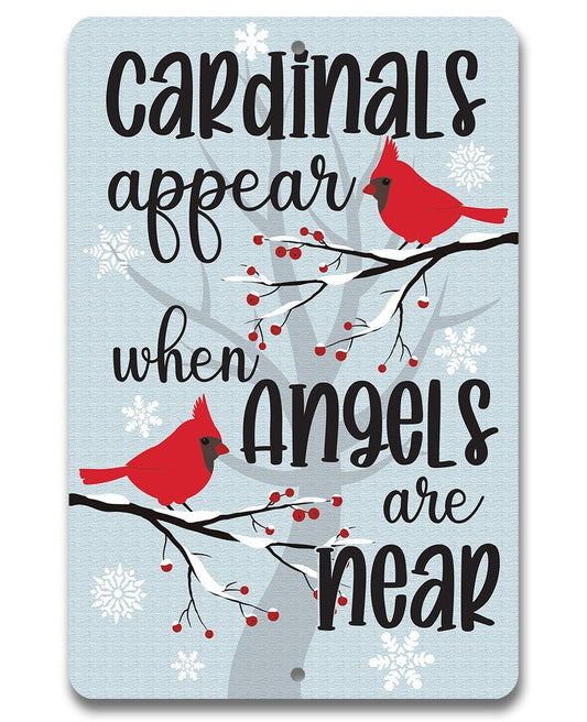 Blue cardinal metal sign with red birds on branches and text reading “Cardinals appear”