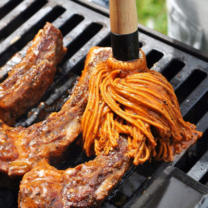 Cotton grilling mop brushing oil onto grilled meat on a barbecue grate