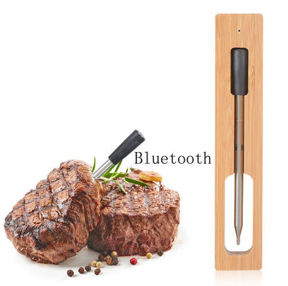 BBQ thermometer probe in light wood charging dock, black cap on metal sensor