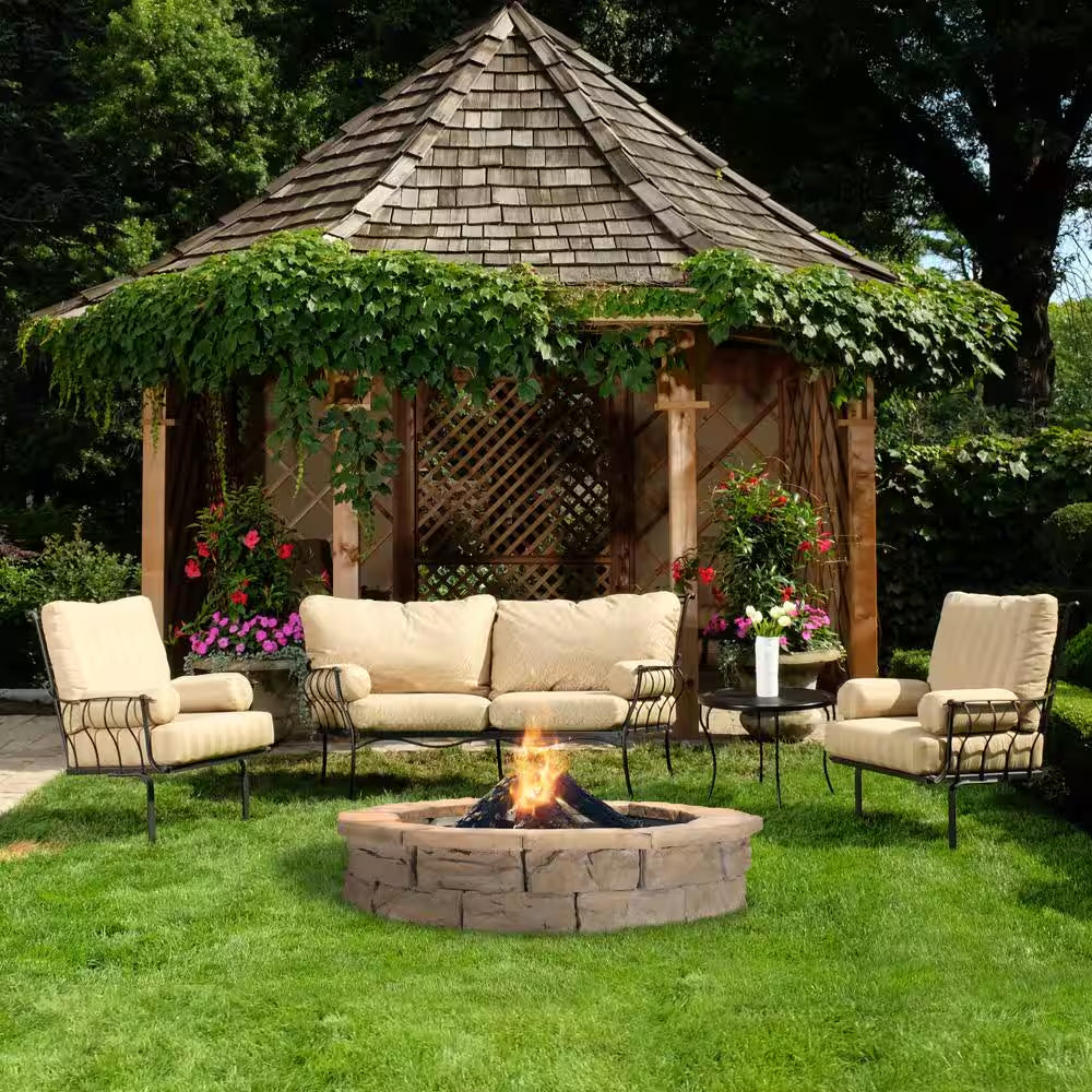 Round stone fire pit with flame, built-in dark metal fire bowl in yard