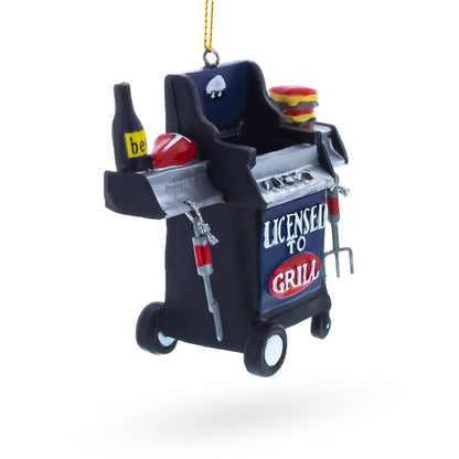 Angled black grill Christmas ornament with “Licensed to Grill” logo and tongs