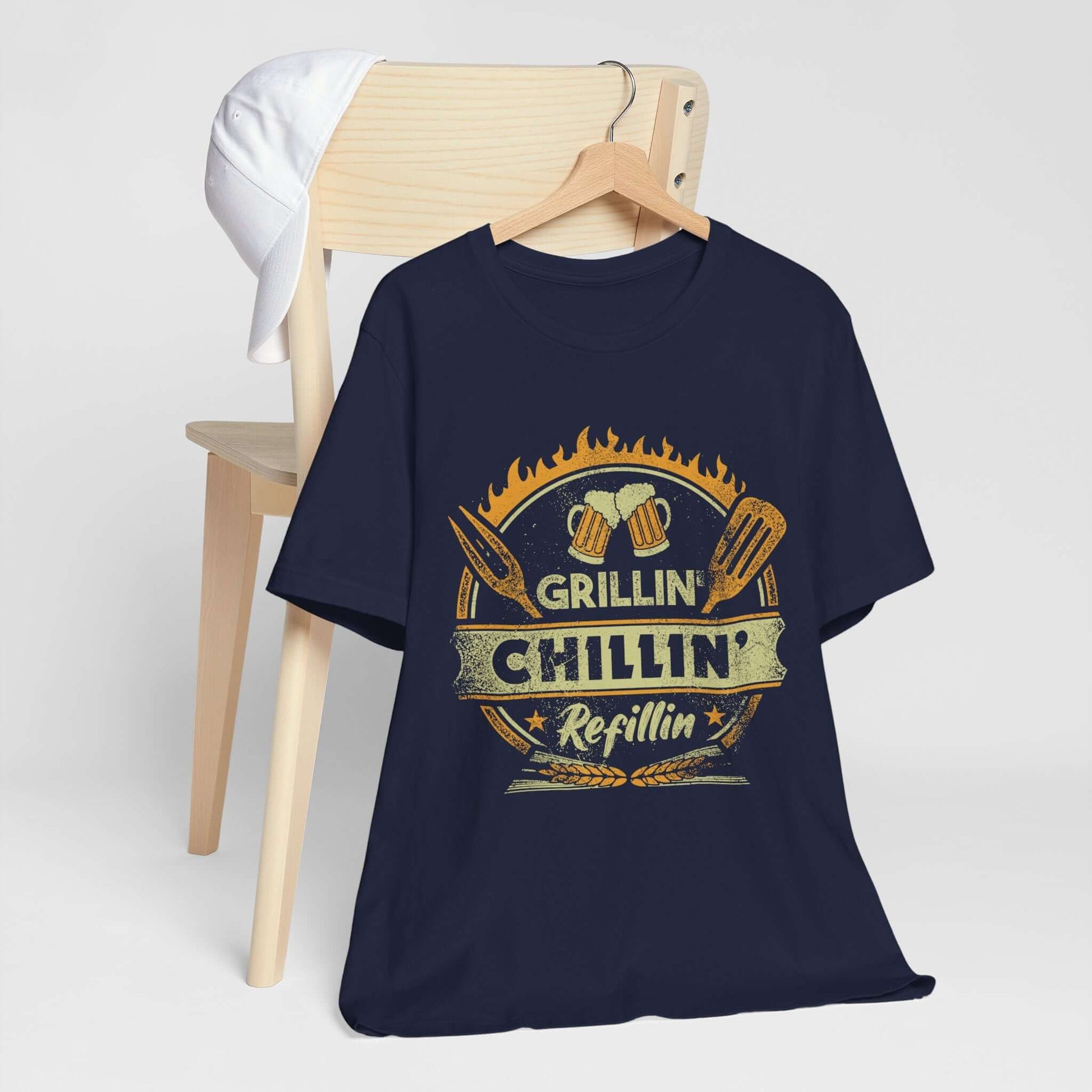 Navy graphic BBQ T-shirt with grill and chillin’ refillin’ emblem on hanger